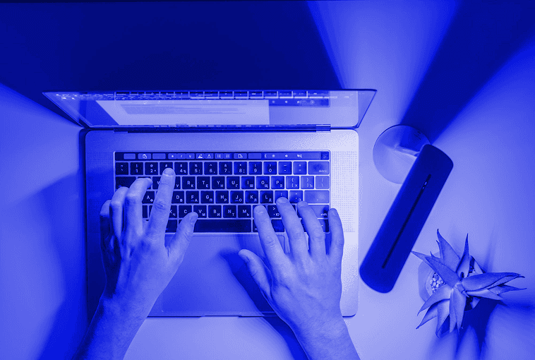 Hands typing on a laptop