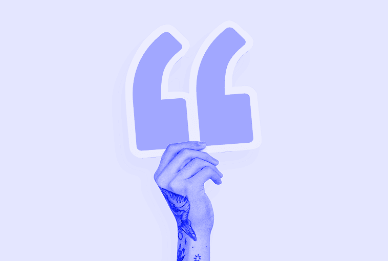 A hand holding a large quotation mark